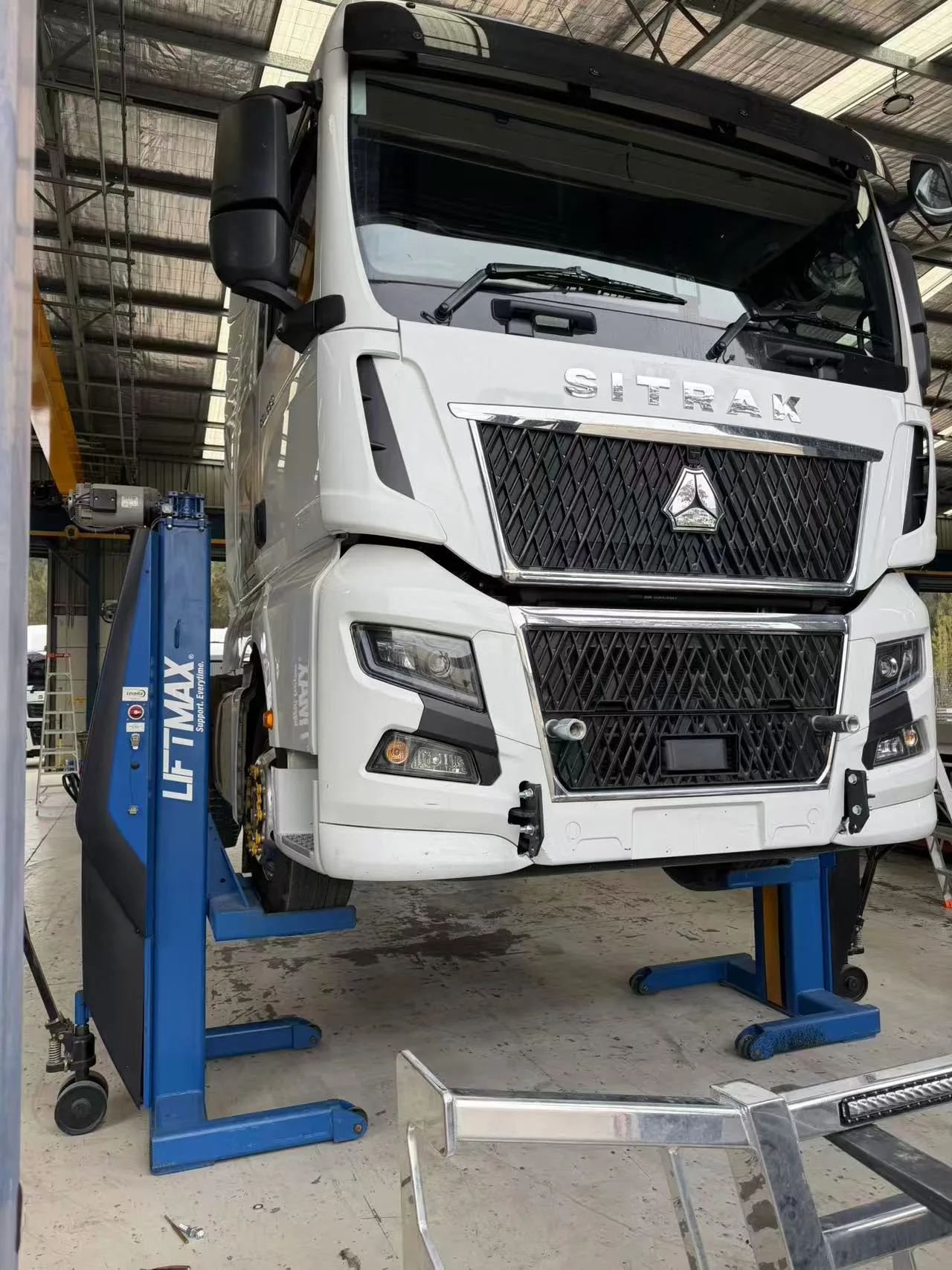 Front of a SITRAK truck raised for workshop work
