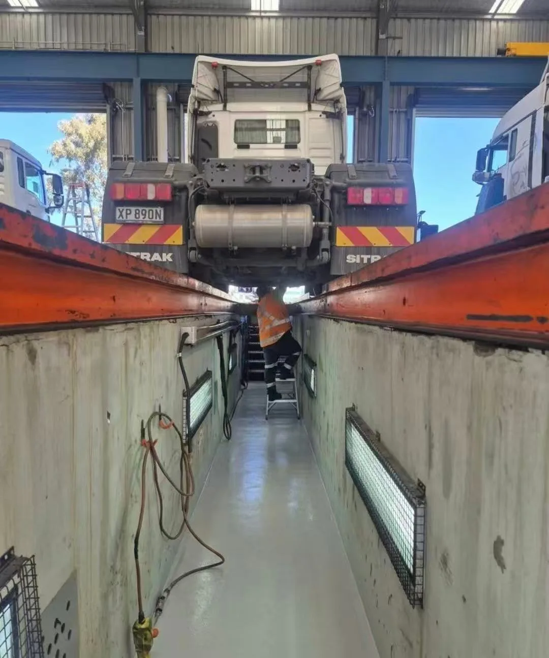SITRAK truck positioned over a workshop inspection pit